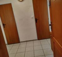 Eingangsflur in einer 2-Zimmer-Wohnung mit Fliesenboden und Holztüren.