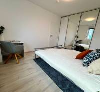 Schlafzimmer in einer 2-Zimmer-Wohnung mit Bett, Schreibtisch und Spiegelschrank.