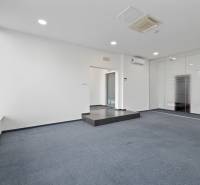 Ein Büro mit Teppichboden, Glaswänden und Klimaanlage.