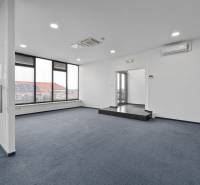 Büros mit Glastüren und Teppichboden, mit Blick auf Dächer und Solarpaneele.