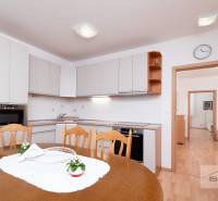 Esszimmer in einer 3-Zimmer-Wohnung mit Küchenzeile und Boden in Holzoptik.