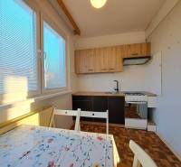 Küche in einer 2-Zimmer-Wohnung mit Holzboden und Esstisch.