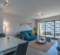 Wohnzimmer in einer Zweizimmerwohnung mit Holzboden und Sitzbereich.