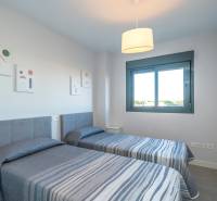 Zwei Einzelbetten in einer 2-Zimmer-Wohnung mit Fenster und dekorativen Bildern an der Wand.