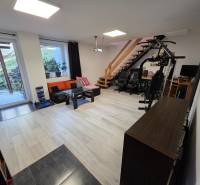 Wohnzimmer in einem Einfamilienhaus mit Holzboden, Fitnessgerät und Treppe.