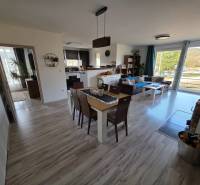 Wohnzimmer eines Einfamilienhauses mit offener Küche und Holzboden.