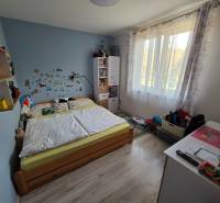 Kinderzimmer in einem Einfamilienhaus mit Holzboden, Bett und Spielzeug.