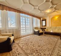 Wohnzimmer in einer 4-Zimmer-Wohnung mit bequemen Sitzgelegenheiten und Teppichen, Boden mit Holzdekor.