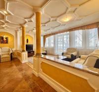 Ein stilvolles Wohnzimmer in einer 4-Zimmer-Wohnung mit Ledersofas, Säulen und einer dekorativen Decke.