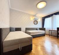 Ein Zimmer in einer 4-Zimmer-Wohnung mit zwei Betten, Klimaanlage und Holzboden.