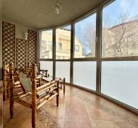 Eine typische Wintergartenwohnung mit vier Zimmern, Rattanmöbeln und großen Fenstern.