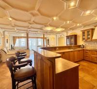 Küche in einer 4-Zimmer-Wohnung mit Holzboden und Barhockern.