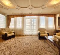 Wohnzimmer mit hellen Sesseln, Teppich und Boden in Holzoptik in einer 4-Zimmer-Wohnung.