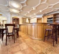 Küche in einer 4-Zimmer-Wohnung mit Esstisch, Holzmöbeln, Fliesenboden und einer interessanten Decke.