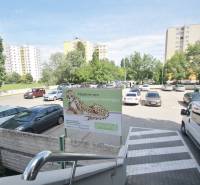Parkplatz auf der Kutlíkova-Straße in Bratislava - Wiesen umgeben von Grünflächen und Wohnhäusern.