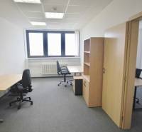 Büros mit Büromöbeln, grauem Teppichboden und heller Wand, bereit für die Arbeit.