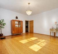 Ein Einfamilienhaus mit einem Kronleuchter, einem Schrank und einem Holzboden in einem geräumigen Wohnzimmer.