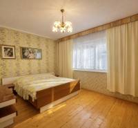 Schlafzimmer im Einfamilienhaus mit Tapeten, Holzelementen und Kronleuchtern.