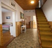 Der Flur eines Einfamilienhauses mit Teppich, Treppe und Bett im nächsten Zimmer.