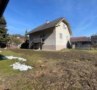 Ein Einfamilienhaus in Terchová mit einem großen Hof und einem Unterstand, umgeben von Gras und Bäumen.