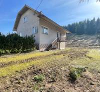 Ein Einfamilienhaus in Terchová mit einem großen Rasenstück, umgeben von Bäumen.