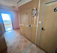 Flur in einer 3-Zimmer-Wohnung mit Holzboden und dekorativem Kranz an der Tür.