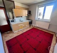 Küche in einer 3-Zimmer-Wohnung mit Holzboden und rotem Teppich.