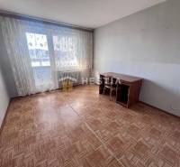 Ein Zimmer in einer 3-Zimmer-Wohnung mit einem Holzboden und großen Fenstern.