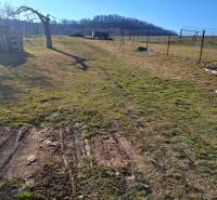 Ein weitläufiger Hof mit Holzpaletten in der Nähe einer Hütte bei Kráľovce Krnišov.
