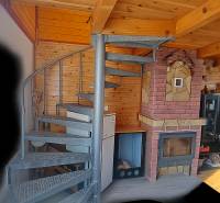 Wendeltreppe, Holzwände und Kamin im Chalet schaffen ein gemütliches Interieur.