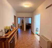 Der Flur in einem Einfamilienhaus mit Fliesen und einem Holzdekor-Schrank.