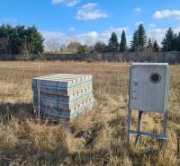 Baugrundstück in Nové Zámky mit Betonpflaster und Stromkasten.