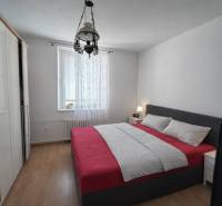 Schlafzimmer mit Bett und Schrank, Boden mit Holzdekor, 3-Zimmer-Wohnung.