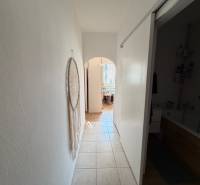 Flur mit Fliesen in einer 3-Zimmer-Wohnung mit Wanddekoration und Blick ins Badezimmer.