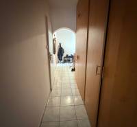 Ein schmaler Flur mit Fliesen und Einbauschränken, der in den Wohnbereich einer 3-Zimmer-Wohnung führt.