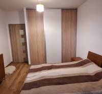 Schlafzimmer in einer 4-Zimmer-Wohnung mit Holzboden und einem großen Schrank.