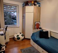 Kinderzimmer in einer 4-Zimmer-Wohnung mit Bett, Schreibtisch und Bodenbelag in Holzoptik.
