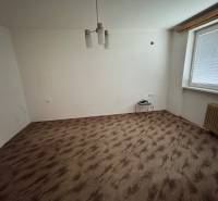 Ein Zimmer in einer Einzimmerwohnung mit einem Boden in Holzoptik und einfacher Beleuchtung.