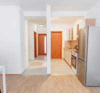 Küche mit Esstisch in einer 2-Zimmer-Wohnung, Boden mit Holzdekor.