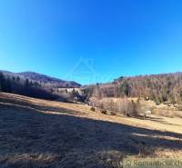 Weitläufige landwirtschaftliche und forstwirtschaftliche Flächen in der Umgebung von Hronec, umgeben von Wäldern und Hügeln.