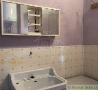 Badezimmer in einem Einfamilienhaus mit Waschbecken und Spiegelschrank an der Wand.