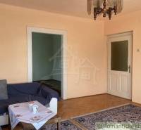 Wohnzimmer in einem Einfamilienhaus mit Holzboden, Sofa und Teppich.