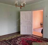 Ein Zimmer im Einfamilienhaus mit Teppich, weißen Türen und einem Kronleuchter.