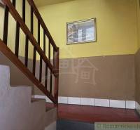 Eine Treppe mit einem Holzgeländer in einem Einfamilienhaus mit gelben Wänden und einem Bild.