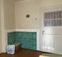 Innenraum eines Einfamilienhauses mit weißen Türen und grün-weißen Fliesen an den Wänden.