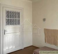 Innenraum eines Einfamilienhauses mit weißen Türen, Wandverkleidung und Bodenbelag in Holzoptik.