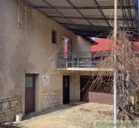 Ein Einfamilienhaus in Bretka mit Balkon, Garage und einem Unterstand für Kletterpflanzen.