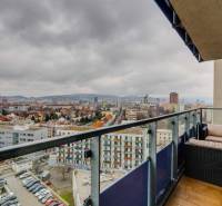 Blick vom Balkon einer 3-Zimmer-Wohnung in der Plynárenská-Straße in Bratislava mit Gartenmöbeln.