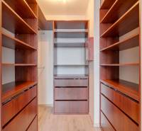 Ein Kleiderschrank in einer 3-Zimmer-Wohnung mit Regalen und einem Boden in Holzoptik.