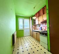 Küche in einer 2-Zimmer-Wohnung mit Küchenzeile, grünen Wänden und schwarz-weißem Boden.